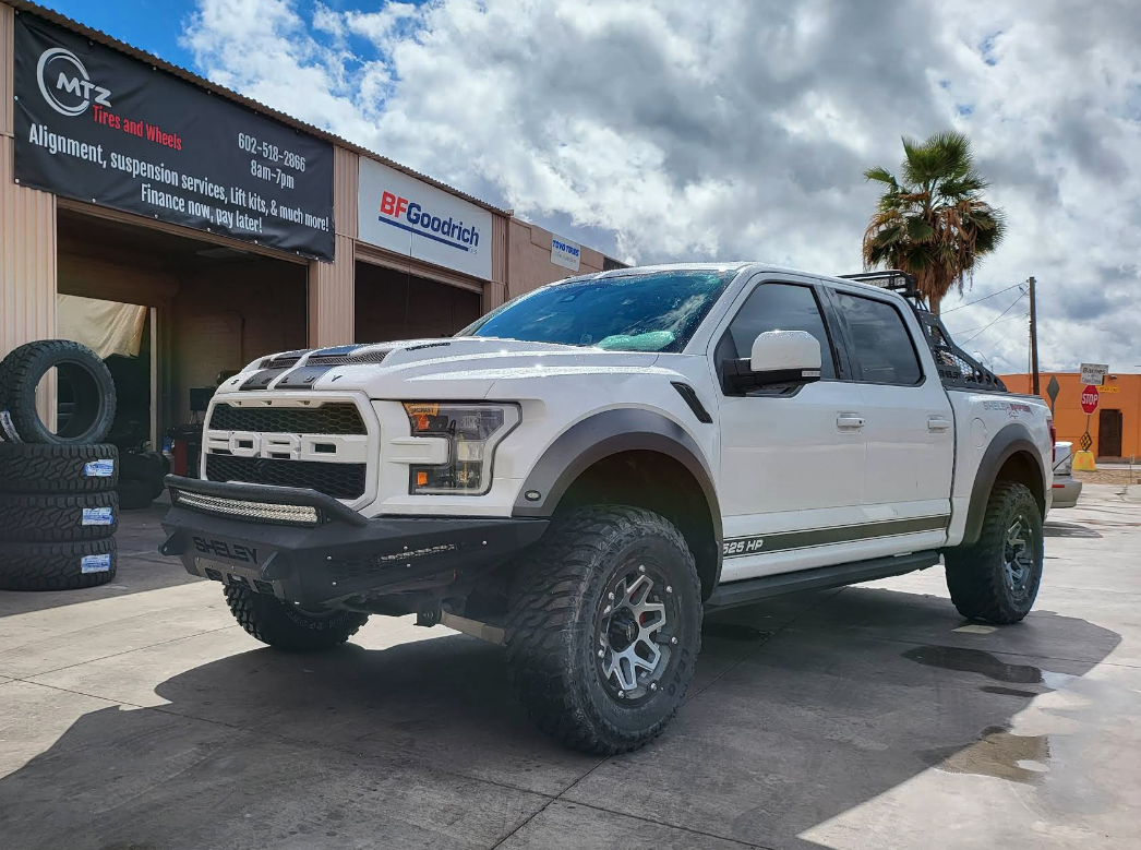 Lifted white Ford Raptor build with custom wheels and off-road tires